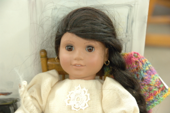 Doll with handwoven blouse and colorful knitted shawl.